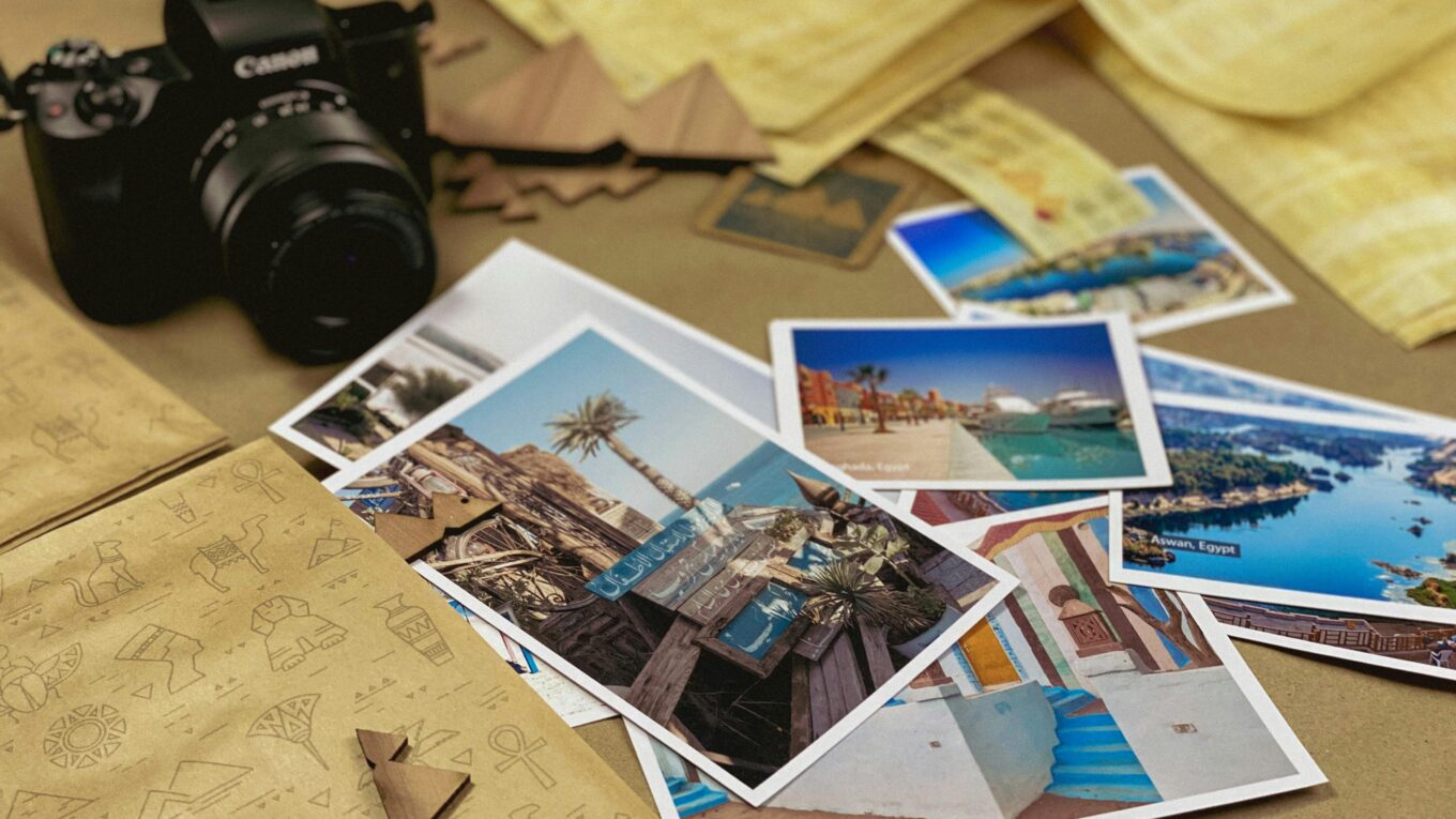 Capturing travel memories with a camera and postcards on a rustic background. Locations Abritel
