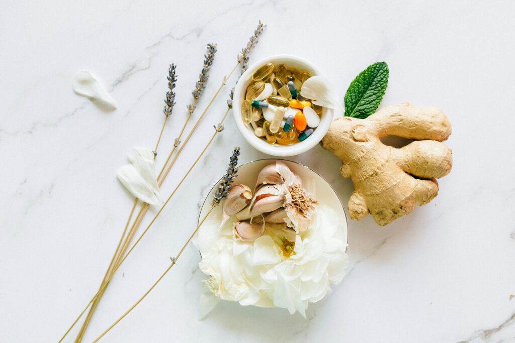 Flat lay of ginger, garlic, flowers, and supplements for holistic health. Best Prostate Supplement